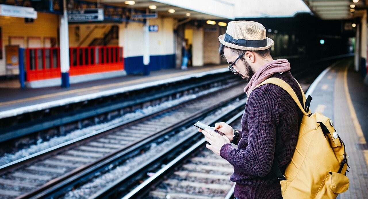 Man checking phone when changing trains for crosscountry emergency timetable